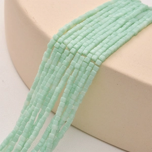 Macro shot of 2mm light green square crystal beads with matte finish for DIY jewelry making