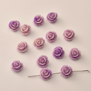 Detailed view of 12mm resin rose flower beads showing through-hole for DIY jewelry making