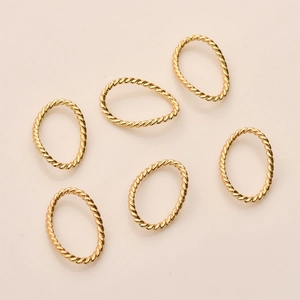 Detailansicht von sechs unregelmäßigen goldenen Anhängern mit Textur für DIY-Schmuck