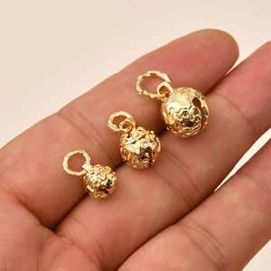 Three sizes of 14K gold plated hollow star pattern bells held in hand for DIY jewelry making