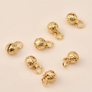 Detailed macro view of 14K gold plated bell pendants with intricate starry sky patterns.