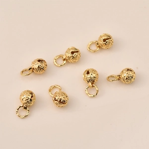 Macro shot of 14K gold plated hollow bell charms with starry sky patterns for DIY jewelry