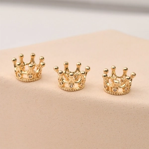 Macro detail of 14k gold plated hollow crown charms with sparkling zircon inlay