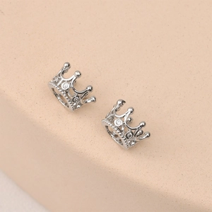 Macro detail of hollow crown charms with 14k gold plating and sparkling cubic zirconia