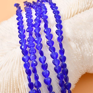 Detailed view of 8mm heart-shaped blue cat-eye stone beads on white coral
