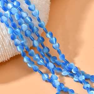Close-up of blue heart-shaped cat eye beads for DIY jewelry making and beadwork accessories