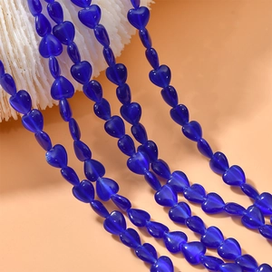 Macro detail of 8mm translucent blue heart-shaped cat-eye beads for DIY jewelry making