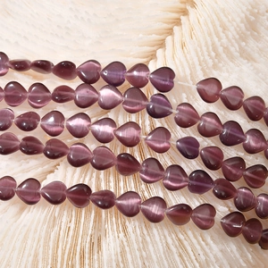 Macro shot of 8mm purple heart cat eye beads with light reflection for jewelry making