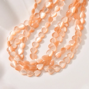 Macro shot of 8mm heart-shaped peach cat eye stone beads for DIY jewelry making