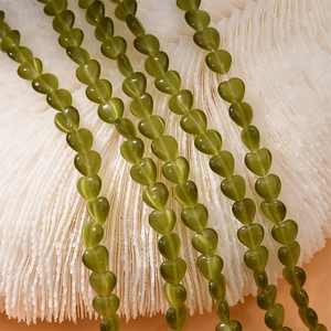 Macro detail of olive green cat eye heart beads for DIY necklace and bracelet jewelry making