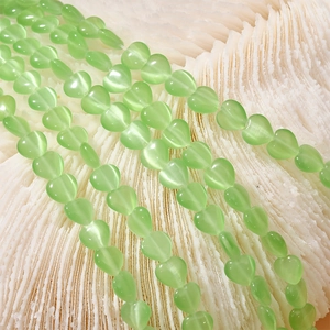 Macro shot of 8mm light green heart cat-eye stone beads for DIY jewelry making
