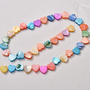 Macro detail of colorful heart-shaped shell beads with natural pearlescent texture