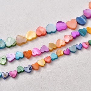 Macro detail of natural colorful shell heart-shaped beads with iridescent pearl luster