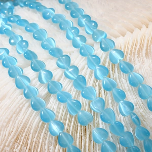 Close-up of 8mm light blue heart cat-eye stone beads for DIY jewelry making