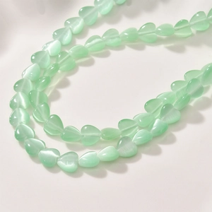 Macro view of 8mm mint green heart-shaped cat eye stone beads for DIY jewelry making