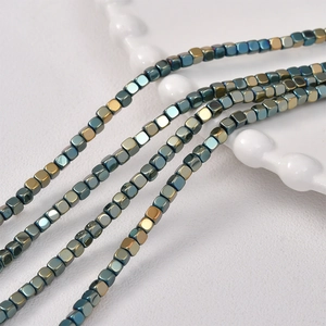Macro shot of 3mm metallic faceted hematite beads in blue, green and gold colors