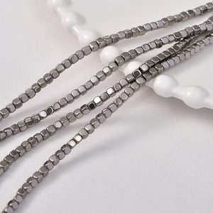Macro detail of 3mm beveled square hematite beads with a polished metallic gunmetal finish