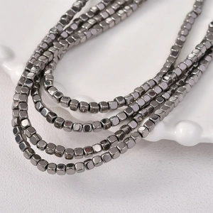 Macro shot of 3mm square hematite beads for jewelry making with metallic dark grey finish