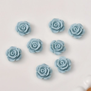 Macro shot of 12mm light blue resin rose charms for DIY jewelry and hair accessories