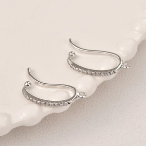Detail van verzilverde C-vormige oorclips met zirkonia inleg en oogjes voor DIY