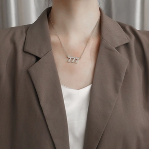 Collana minimalista in acciaio inossidabile argento con ciondolo 777 su una modella
