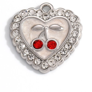 Detailed close-up of heart charm with red cherry rhinestones and white enamel finish