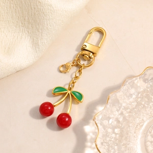 Chic gold stainless steel keychain featuring a vibrant red cherry pendant with green leaves