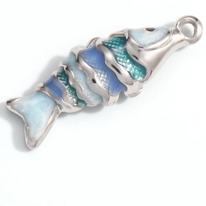 Macro detail of flexible silver fish pendant with blue-green gradient glitter enamel