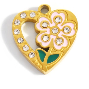 Macro shot of gold heart pendant with pink enamel flower and sparkling rhinestones