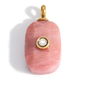 Dettaglio del ciondolo in pietra rosa con chiusura dorata e cristallo centrale