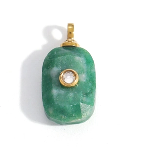 Dettaglio macro di un ciondolo rettangolare in pietra verde con zircone e bordo oro