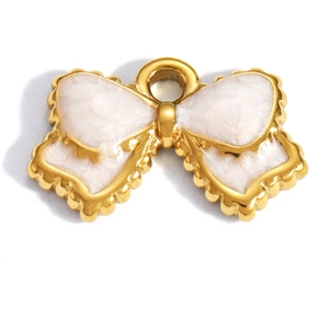 Close-up of gold-plated bow charm with white enamel and circular hanging ring detail
