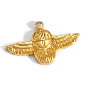 Macro detail of a gold plated scarab beetle charm with detailed engraved wings