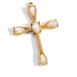 Detail of vintage gold cross pendant with teardrop gems and beaded edge texture