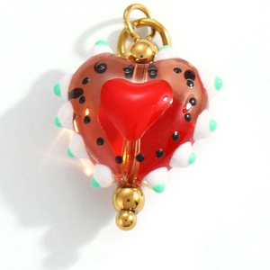 Macro detail of a heart-shaped translucent red resin pendant with white beaded edges