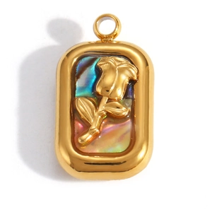 Makro-Detail eines goldenen rechteckigen Anhängers mit Regenbogenmuschel und Rose