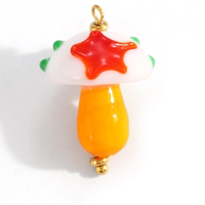 Close-up of a colorful mushroom charm with red stars and gold metal hanging loop
