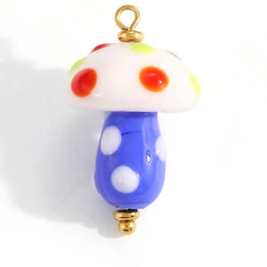 Macro detail of a colorful mushroom charm with vibrant polka dots and gold finish loop