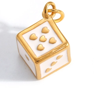 Makroaufnahme eines goldenen Würfelanhängers mit Herzmuster und weißem Emaille