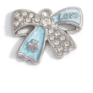 Detailed view of silver bow pendant with blue enamel, sparkling crystals and Love engraving