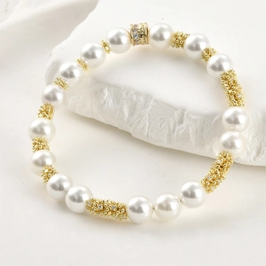 White pearl bracelet with gold plated zircon snowflake spacers on stone base