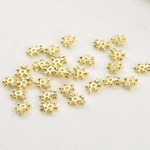Macro view of 4mm gold plated snowflake spacers with cubic zirconia for DIY jewelry