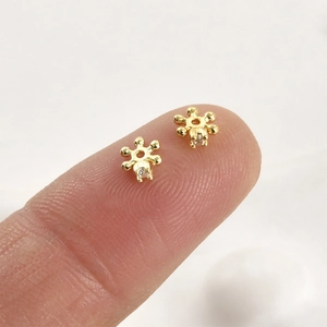 Detailed macro view of 4mm gold plated snowflake beads with zircons for jewelry making