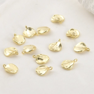 Detalle de colgantes de hoja bañados en oro de 14k con superficie texturizada para DIY