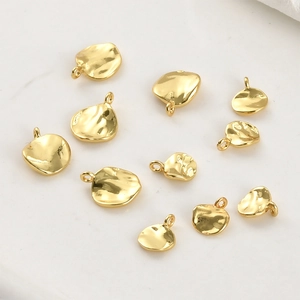Detalle de colgantes de hoja bañados en oro de 14k con textura para joyería artesanal