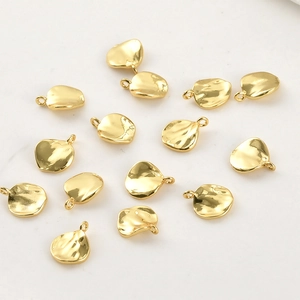 Detalle de dijes de hoja chapados en oro de 14k para la creación de joyas DIY
