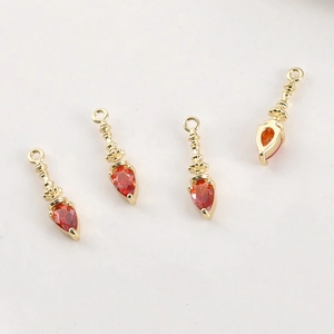 Detailed view of four vintage gold plated pendants with teardrop red zircon stones