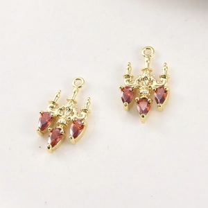 Macro shot of gold-plated chandelier pendants with red pear-cut zircon for DIY jewelry