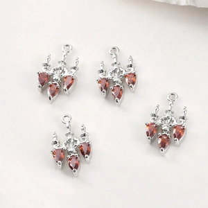 Close-up of four silver vintage chandelier pendants with red teardrop stones for DIY jewelry