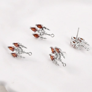 Macro detail of silver plated earring findings with triple red pear-shaped zircons